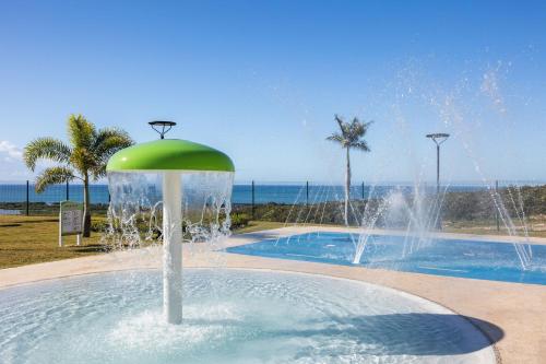 a fountain in a pool with the ocean in the background at Holiday Inn Ponce & El Tropical Casino by IHG in Ponce