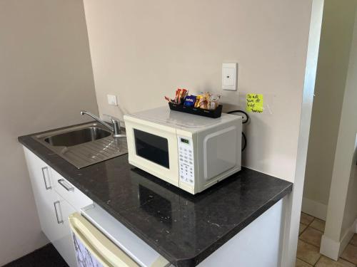 a microwave sitting on a counter in a kitchen at Kalua Motel in Bundaberg