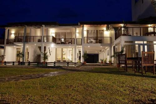 a large white building with a yard in front of it at Shavara Beach in Ahangama