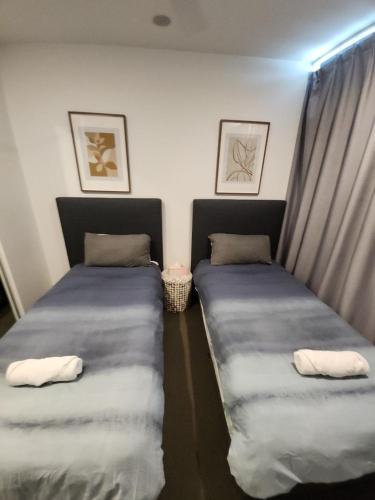 two twin beds in a room with curtains at Southbank Apartment with pool Brisbane CBD Hosted by Homestayz in Brisbane