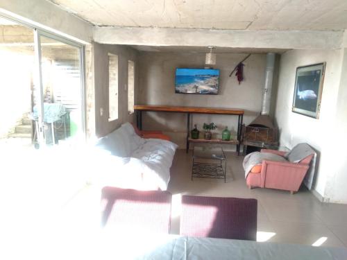 a living room with a couch and chairs and a fireplace at Cabañas Mirador de Soledad in El Quisco