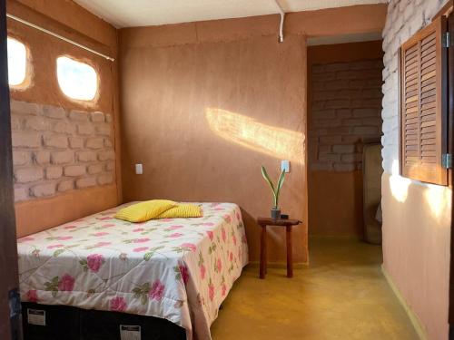 a bedroom with a bed and a table in it at Casa de Praia Itacimirim Bahia - Piscina e Conforto in Camacari