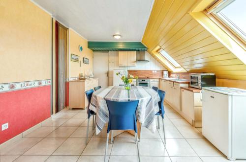 une cuisine avec une table et des chaises dans une pièce dans l'établissement Appartement charmant avec vue sur la mer - Saint-Pol-de-Léon, 60m², à Saint-Pol-de-Léon