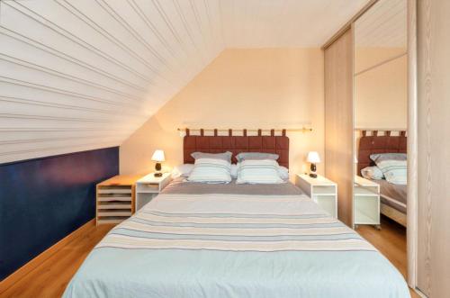 a bedroom with a large bed with two night stands at Appartement charmant avec vue sur la mer - Saint-Pol-de-Léon, 60m² in Saint-Pol-de-Léon