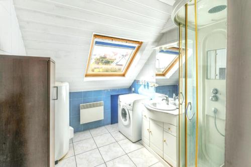 a bathroom with a sink and a washing machine at Appartement charmant avec vue sur la mer - Saint-Pol-de-Léon, 60m² in Saint-Pol-de-Léon