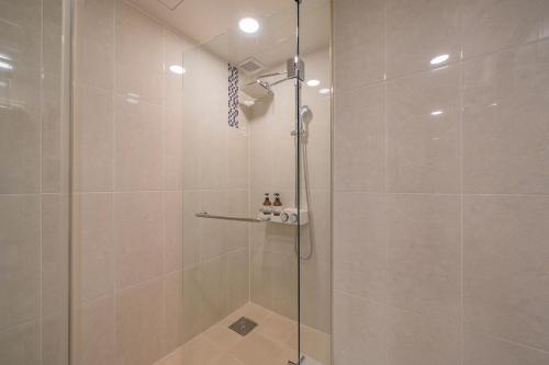 a shower with a glass door in a bathroom at Hotel Stayon in Geoje 