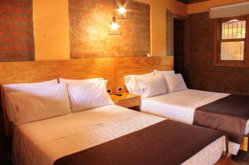 a hotel room with two beds and a window at Rancho San Antonio in Salento