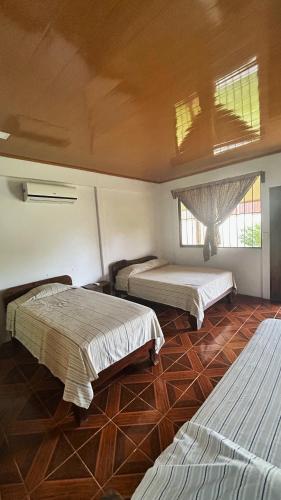 a bedroom with three beds in a room at Cabinas Caño Negro in Los Chiles