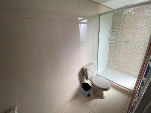 a white bathroom with a toilet and a shower at The Box Container House casa oceano in Imbituba