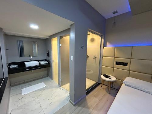 a bathroom with a shower and a toilet and a sink at Motel Ermitage in Blumenau