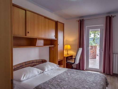a bedroom with a bed and a desk and a window at Apartments with swimming pool Kampor, Rab - 23600 in Rab