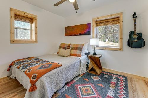 a bedroom with a bed and a guitar on the wall at Remote Home with Deck and Grill in Scenic Tuckasegee! in Tuckasegee