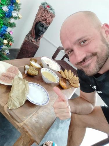 a man giving a thumbs up next to a table with food at RKO Villa27 - Unawatuna in Habaraduwa