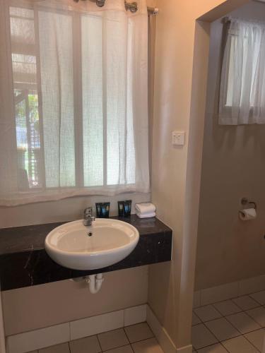a bathroom with a sink and a window at Kalua Motel in Bundaberg