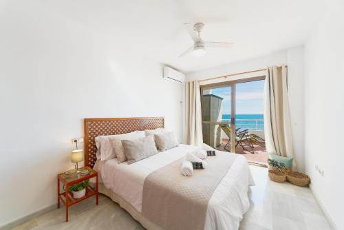 a bedroom with a bed with a view of the ocean at ROSE I Vistas and direct access to the sea Mijas Costa in Málaga