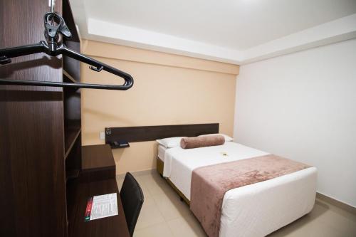 ポルト・ヴェーリョにあるHotel Nativoのベッド1台とマイクが備わる客室です。