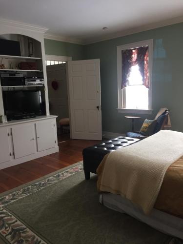 a bedroom with a bed and a television in it at Stephen Clay Homestead Bed and Breakfast in Candia
