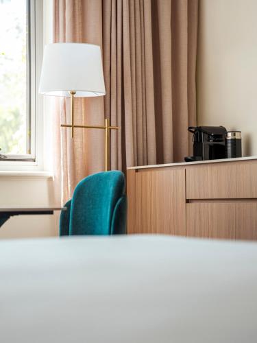 a room with a lamp and a green chair at Lenna Of Hobart in Hobart