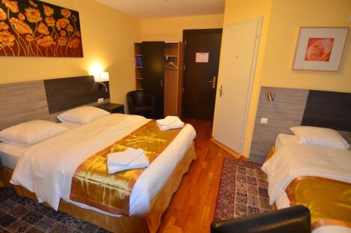 a hotel room with two beds and a chair at Beausite in Lausanne
