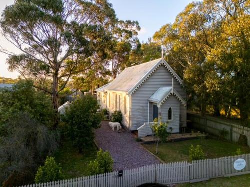 a dog standing in front of a small house at The Seaside Chapel, Port Fairy in Port Fairy