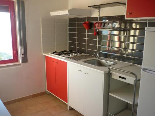 a small kitchen with a sink and a stove at Residence San Antonio in Marina di Camerota
