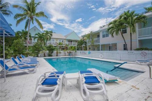 a swimming pool with lounge chairs and a resort at Dee's Dream Sunset Condo - #151 in Key West