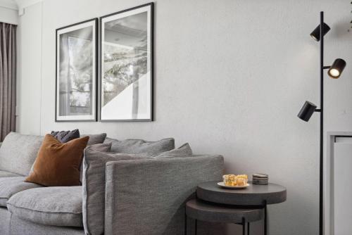 a living room with a gray couch and a table at Horizons 410 in Jindabyne