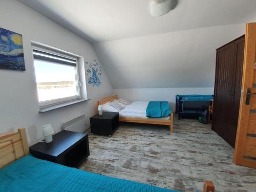 a small bedroom with a bed and a window at House near S owi ski Park and Sandy Beach in Smołdzino