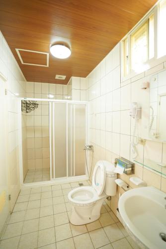a bathroom with a shower and a toilet and a sink at 金華民宿 in Jincheng