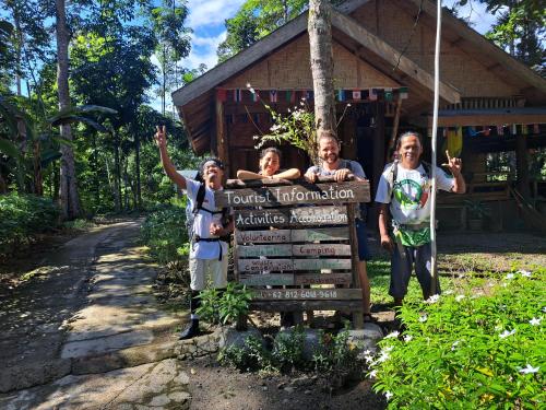 a group of people standing next to a sign at Eco Conservation Landak Luxury Tents in Bukit Lawang