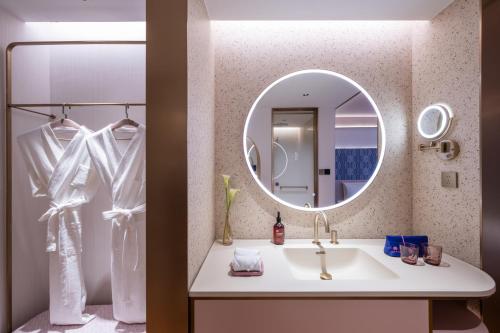 武漢市にあるManxin Hotel Wuhan Hankou Fanhai CBD Xinhua Roadの洗面台と鏡のあるバスルーム