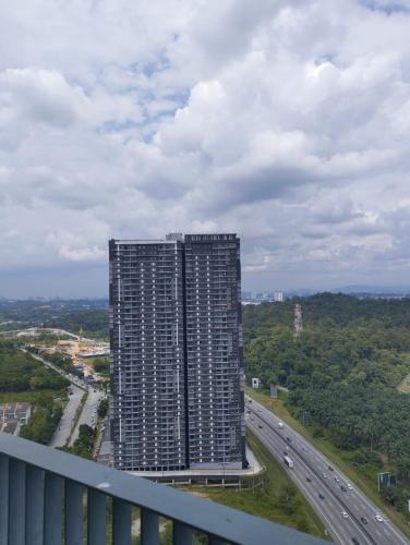 a tall apartment building on the side of a highway at The Luxe Sanctuary in Southville City in Bangi