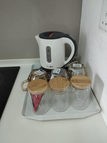 a tea pot and four containers on a shelf at The Luxe Sanctuary in Southville City in Bangi