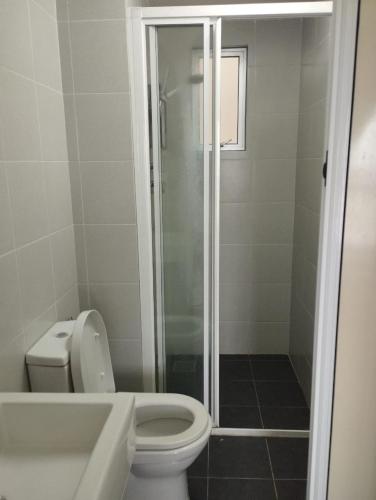 a bathroom with a toilet and a glass shower at The Luxe Sanctuary in Southville City in Bangi