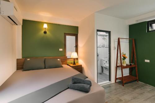 a bedroom with a bed and a green wall at Villaxe Toycan, 50m to Hoan Kiem lake - by Antique in Hanoi