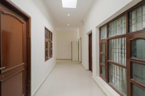 an empty hallway with a door and windows at Hotel O Hc Plaza in Kharar