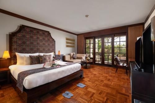 a bedroom with a large bed and a living room at Ayodya Resort Bali in Nusa Dua