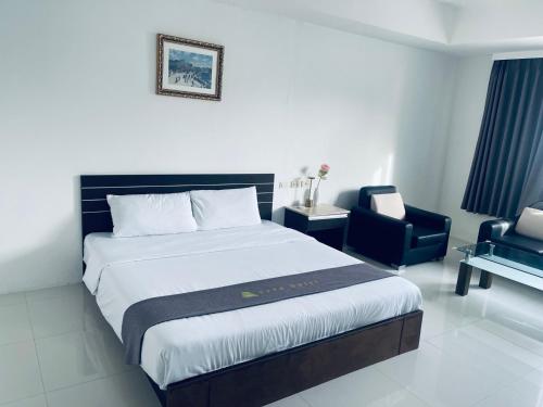 a bedroom with a large bed and a chair at Vera Hotel in Angeles