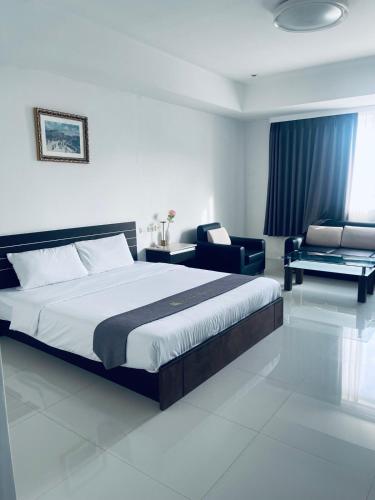 a bedroom with a bed and a couch and a chair at Vera Hotel in Angeles