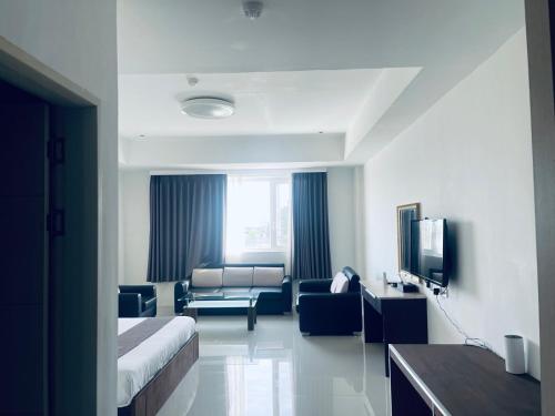 a hotel room with a bed and a couch at Vera Hotel in Angeles