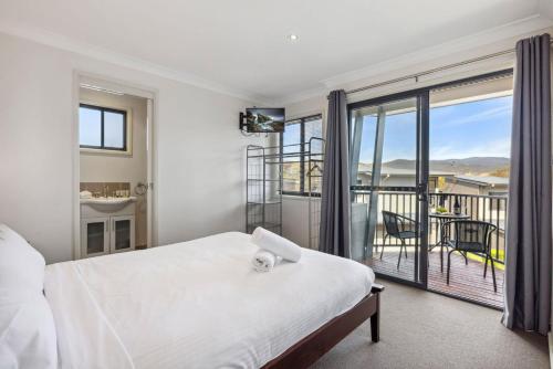 Un dormitorio con una cama y un balcón. en Apres 9, en Jindabyne