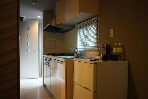 a kitchen with a sink and a stove top oven at Alba HOTEL & Glamping in Nishinoura