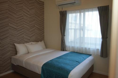 a bedroom with a bed and a window with curtains at Alba HOTEL & Glamping in Nishinoura