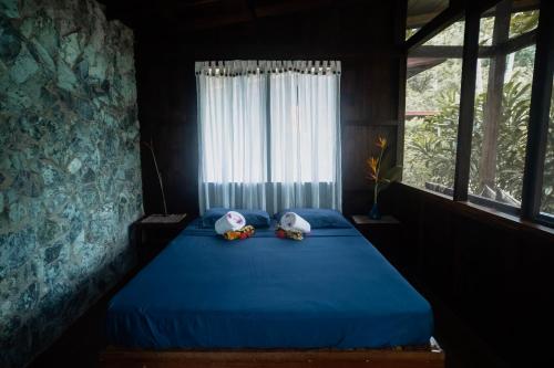 two stuffed animals sitting on a blue bed in a room at Kiao Beach in Anepahan