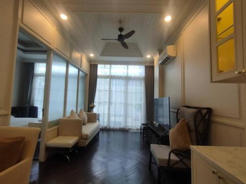 a living room with a couch and a tv at Grand Florida Jomtien Pool Access in Sattahip
