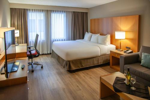 a hotel room with a bed and a couch at iHOTEL & Conference Centre Red Deer in Red Deer