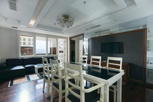 a living room with a table and chairs and a couch at Samdi Grand Danang in Da Nang