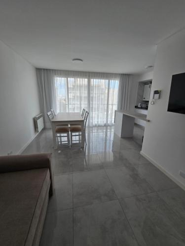 a living room with a table and chairs and a couch at Depto Perla Norte in Mar del Plata