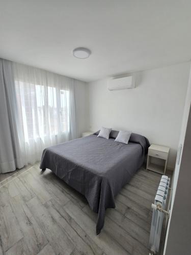 a bedroom with a bed in a white room at Depto Perla Norte in Mar del Plata