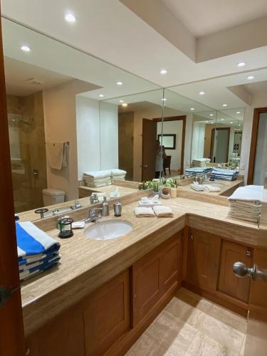a bathroom with a sink and a large mirror at Mayan Playa Departamento Uxmal in Acapulco